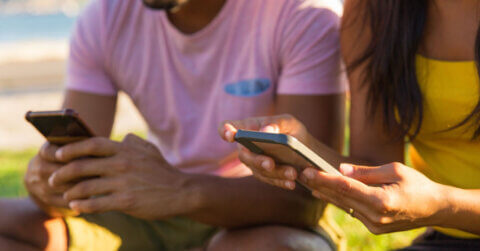 2 personnes recevant un sms marketing sur leur téléphone.