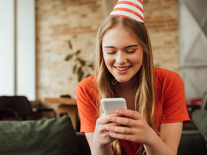 Giovane donna che riceve un SMS di compleanno inviato dalla piattaforma SMSup.