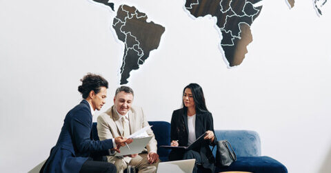 Trois professionnels travaillent sur la stratégie des SMS à l'international.