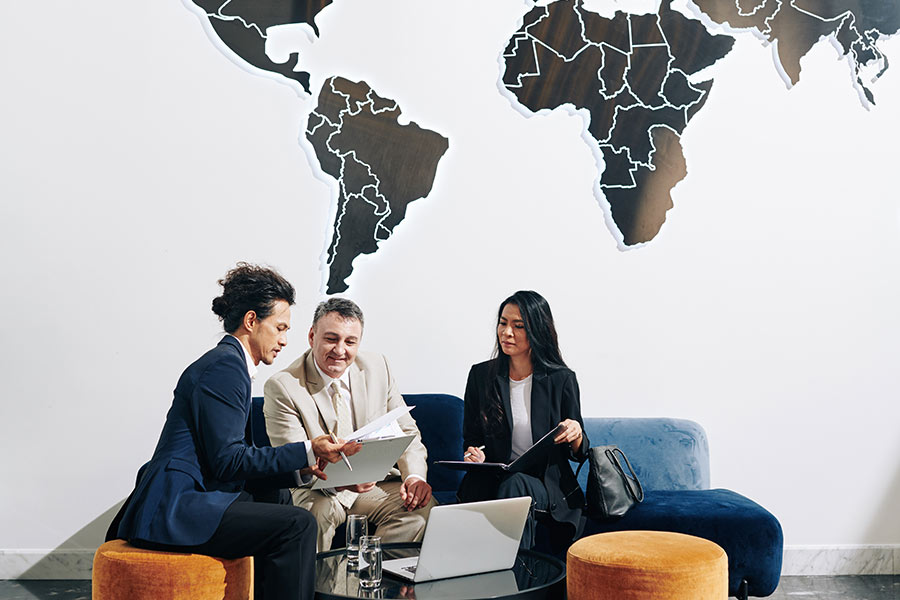 Trois professionnels travaillent sur la stratégie des SMS à l'international.