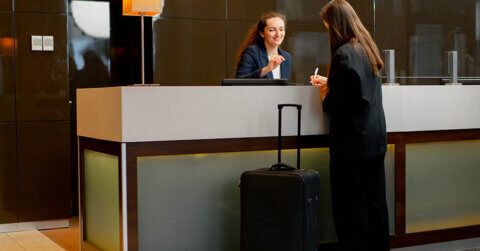 Frau an der Rezeption eines Hotels dank einer Marketingkampagne zum Jahresende.