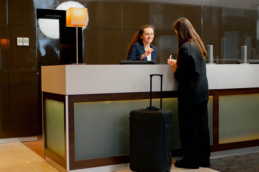 Frau an der Rezeption eines Hotels dank einer Marketingkampagne zum Jahresende.